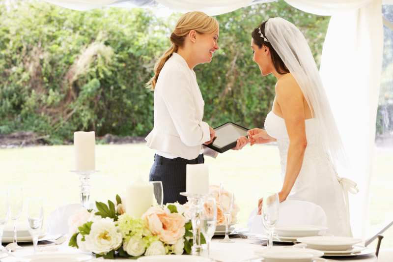 Braut bespricht sich im Brautkleid mit Hochzeitsplanerin