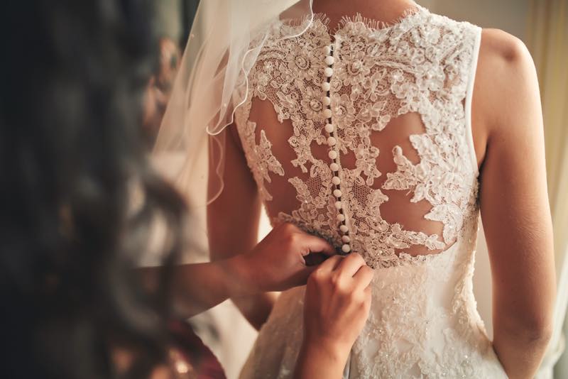 Das Brautkleid wird zugeknöpft